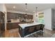 Stylish kitchen island featuring bar stool seating, quartz countertops, and modern pendant lighting at 527 Macintosh Ln, Danville, IN 46122