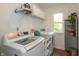 Well-equipped laundry room with modern washer and dryer, storage shelves, and natural light from the window at 527 Macintosh Ln, Danville, IN 46122