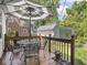 Inviting back deck with an umbrella-covered table, chairs, and view of backyard with garage at 5342 Central Ave, Indianapolis, IN 46220