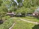 Landscaped backyard featuring a winding stone pathway, mature trees, and green lawn at 5342 Central Ave, Indianapolis, IN 46220