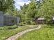 Landscaped backyard featuring a winding stone pathway, mature trees, and green lawn at 5342 Central Ave, Indianapolis, IN 46220