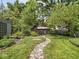 Landscaped backyard featuring a winding stone pathway, mature trees, and green lawn at 5342 Central Ave, Indianapolis, IN 46220