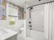 Bright bathroom featuring a shower over tub with white tiles and designer wallpaper at 5342 Central Ave, Indianapolis, IN 46220