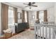 Cozy bedroom with three windows, a ceiling fan, neutral decor, and hardwood floors at 5342 Central Ave, Indianapolis, IN 46220