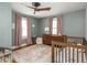 Calm bedroom with hardwood floors, a ceiling fan, a wooden crib, and muted rose color scheme at 5342 Central Ave, Indianapolis, IN 46220