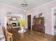 Open dining room with wooden table, vintage armoire, and view to living room offers ample space for entertaining guests at 5342 Central Ave, Indianapolis, IN 46220