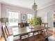 Sun-filled dining room with wooden table, chandelier, and large windows offers an inviting space for meals and gatherings at 5342 Central Ave, Indianapolis, IN 46220