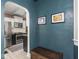 Inviting entryway with blue accent wall, dark wood chest, and framed artwork leading to kitchen with stainless steel appliances at 5342 Central Ave, Indianapolis, IN 46220
