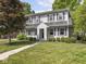 Beautiful home with a landscaped front yard, manicured lawn, mature trees, and brick detail on the chimney at 5342 Central Ave, Indianapolis, IN 46220