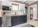 Updated kitchen featuring stainless steel appliances, granite countertops, tile backsplash, and ample cabinet space at 5342 Central Ave, Indianapolis, IN 46220
