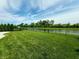 Expansive backyard with lush lawn, black fence, and serene pond view, creating a peaceful outdoor retreat at 5379 Marigold Dr, Plainfield, IN 46168