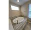 Bright bathroom with a large soaking tub, neutral tile and a large window at 5379 Marigold Dr, Plainfield, IN 46168