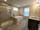 Well-lit bathroom featuring double sinks, soaking tub, and separate shower with glass door at 5379 Marigold Dr, Plainfield, IN 46168