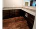 This butler's pantry features beautiful granite countertops and dark cabinetry with wood-look flooring at 5379 Marigold Dr, Plainfield, IN 46168