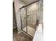 Tile shower with a sliding glass door and a built-in shower caddy at 5379 Marigold Dr, Plainfield, IN 46168