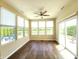 An empty sunroom has multiple windows, a ceiling fan, and a glass sliding door to the exterior at 5379 Marigold Dr, Plainfield, IN 46168
