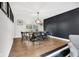 Dining room featuring hardwood floors, modern light fixture, and dark accent wall at 5506 Kessler Blvd N Dr, Indianapolis, IN 46228