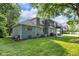 Back exterior with a grassy lawn, patio and a balcony at 5506 Kessler Blvd N Dr, Indianapolis, IN 46228
