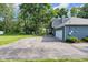Side exterior featuring a large driveway and attached garage at 5506 Kessler Blvd N Dr, Indianapolis, IN 46228