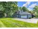 Side exterior featuring an attached garage, lawn and trees at 5506 Kessler Blvd N Dr, Indianapolis, IN 46228