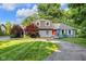 Charming house with red door, brick, dormer windows, and lush landscaping at 5506 Kessler Blvd N Dr, Indianapolis, IN 46228