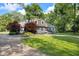 Charming house with red door, brick, dormer windows, and lush landscaping at 5506 Kessler Blvd N Dr, Indianapolis, IN 46228