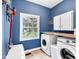 This laundry room features a window with a scenic view, washer, dryer, and convenient cabinet space for supplies at 5506 Kessler Blvd N Dr, Indianapolis, IN 46228