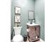 Cozy powder room featuring neutral paint, decorative mirror, and floating sink at 5506 Kessler Blvd N Dr, Indianapolis, IN 46228