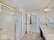 Well-lit bathroom featuring a shower with glass door, double sinks, and neutral color scheme at 5768 Blue Sky Dr, Whitestown, IN 46075