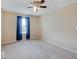 Comfortable bedroom with plush carpet, ceiling fan, and large window with blue curtains at 5768 Blue Sky Dr, Whitestown, IN 46075