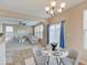 Bright dining area with a chandelier, blue curtains, and a view of the living room at 5768 Blue Sky Dr, Whitestown, IN 46075