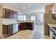 Open kitchen with stainless steel appliances, wood cabinets, and an island with a sink at 5768 Blue Sky Dr, Whitestown, IN 46075