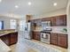 Well-lit kitchen with stainless steel appliances, wooden cabinetry, and tile floors at 5768 Blue Sky Dr, Whitestown, IN 46075