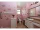 Pink bathroom featuring floral wallpaper, a vanity sink, toilet and a floral arrangement at 60 S 8Th Ave, Beech Grove, IN 46107