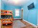 Bright blue bedroom with a bunk bed, wood floors and a flat screen television on the wall at 60 S 8Th Ave, Beech Grove, IN 46107