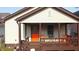 Home exterior featuring a covered front porch with a orange front door and brown accents at 60 S 8Th Ave, Beech Grove, IN 46107