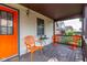 Covered front porch with orange metal furniture including three chairs and a table at 60 S 8Th Ave, Beech Grove, IN 46107