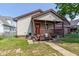 Charming single-story home with neutral siding, brown trim, and a covered front porch with a red front door at 60 S 8Th Ave, Beech Grove, IN 46107