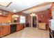 Bright kitchen featuring tile floors, wooden cabinets, brick accent wall, stainless steel appliances and new fixtures at 60 S 8Th Ave, Beech Grove, IN 46107