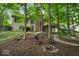 Secluded backyard with mature trees, fire pit, and seating, perfect for relaxing and entertaining at 6363 Harmonridge Ct, Indianapolis, IN 46278