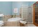 Bathroom with soaking tub, glass block divider, and separate shower at 6363 Harmonridge Ct, Indianapolis, IN 46278