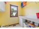 Bright laundry room with yellow walls, countertop, and window view at 6363 Harmonridge Ct, Indianapolis, IN 46278