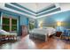 Bright main bedroom with hardwood floors, tray ceiling, and large windows for natural light at 6363 Harmonridge Ct, Indianapolis, IN 46278