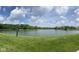 Community pond with grassy shoreline offering serene views and recreation at 6363 Harmonridge Ct, Indianapolis, IN 46278