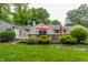 Backyard boasts a wooden deck, lush lawn, and mature landscaping at 6455 N Olney St, Indianapolis, IN 46220