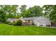Large backyard includes a deck, green lawn, generator and mature trees at 6455 N Olney St, Indianapolis, IN 46220