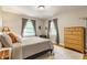 Neutral bedroom showcases natural light, hardwood floors, light grey walls and a well-dressed bed at 6455 N Olney St, Indianapolis, IN 46220