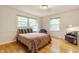 Well-lit bedroom with hardwood floors, complemented by a bed, two chairs, and natural light from windows at 6455 N Olney St, Indianapolis, IN 46220