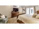 Cozy bedroom featuring a wooden dresser with a TV and a comfortable armchair at 6455 N Olney St, Indianapolis, IN 46220
