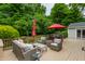 A wooden deck is surrounded by green trees, with a red umbrella at 6455 N Olney St, Indianapolis, IN 46220